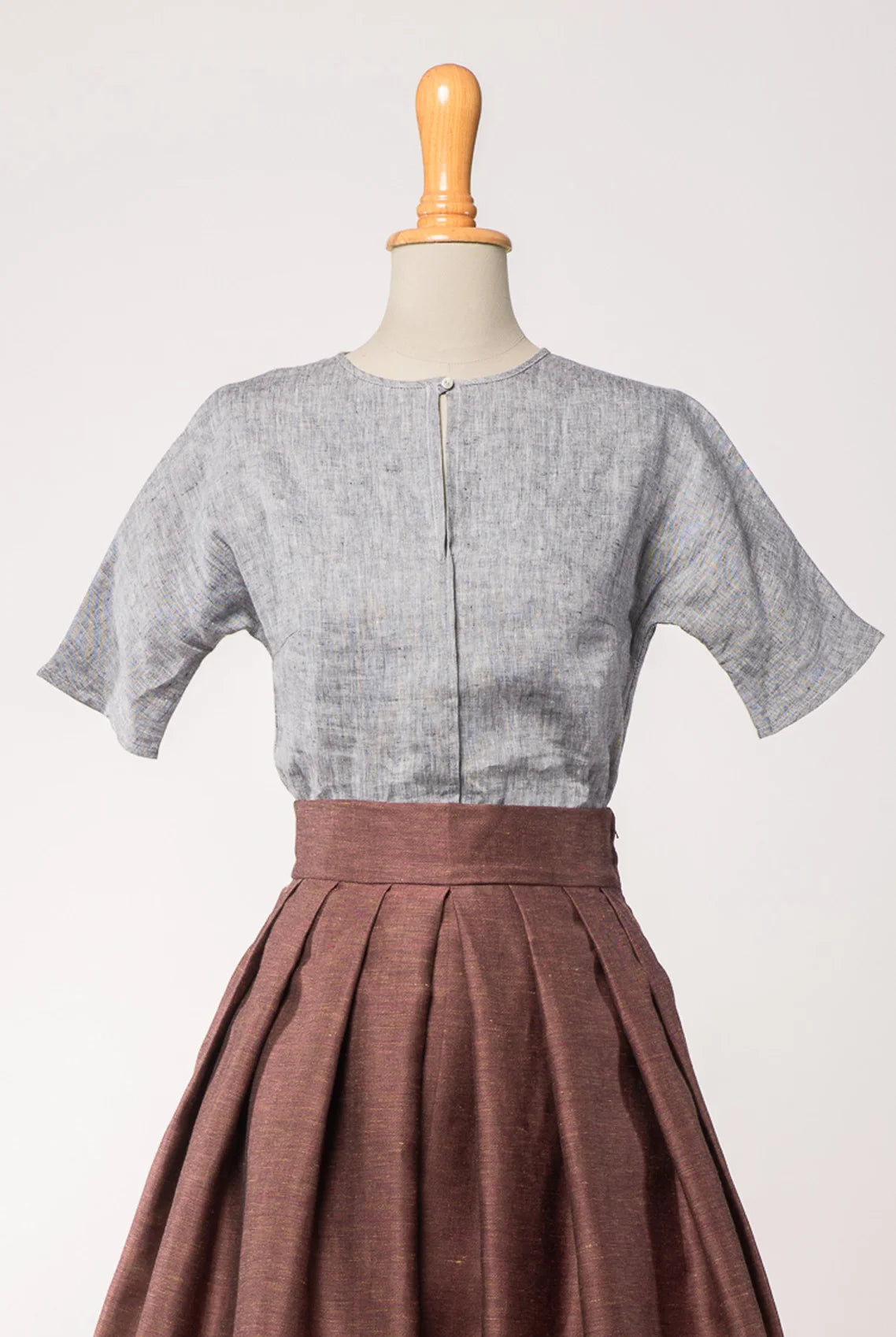 Bluse Romy aus blaugrauem Bio-Leinen, kombiniert mit Trachtenrock Charlie in Malve – Frontansicht auf Büste, nachhaltig gefertigt von Zirbenfux