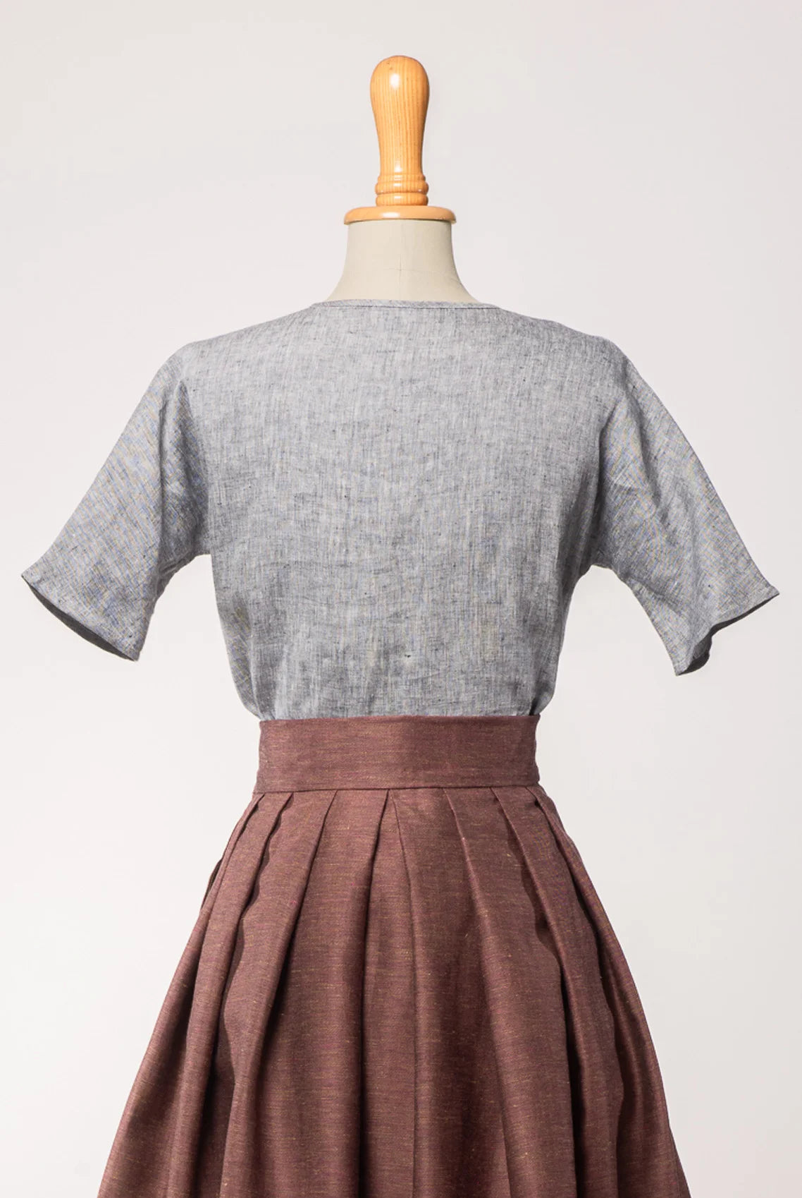 Bluse Romy aus blaugrauem Bio-Leinen, kombiniert mit Trachtenrock Charlie in Malve – Rückansicht auf Büste, handgefertigt in München von Zirbenfux