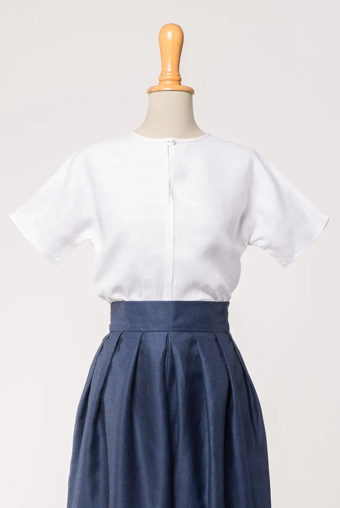 Bluse Romy aus weißem Bio-Leinen, kombiniert mit Hosenrock Audrey in Tintenblau – Frontansicht auf Büste, handgefertigt in München von Zirbenfux
