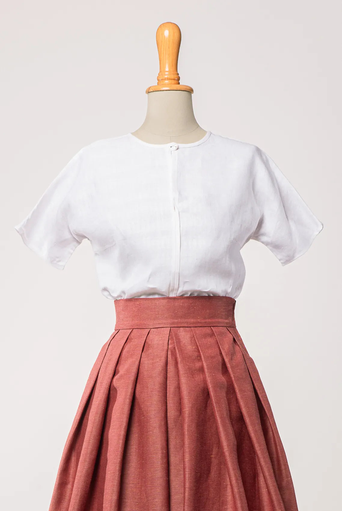 Bluse Romy aus weißem Bio-Leinen, kombiniert mit Trachtenrock Charlie in pinker Beere – Frontansicht auf Büste, handgefertigt in München von Zirbenfux