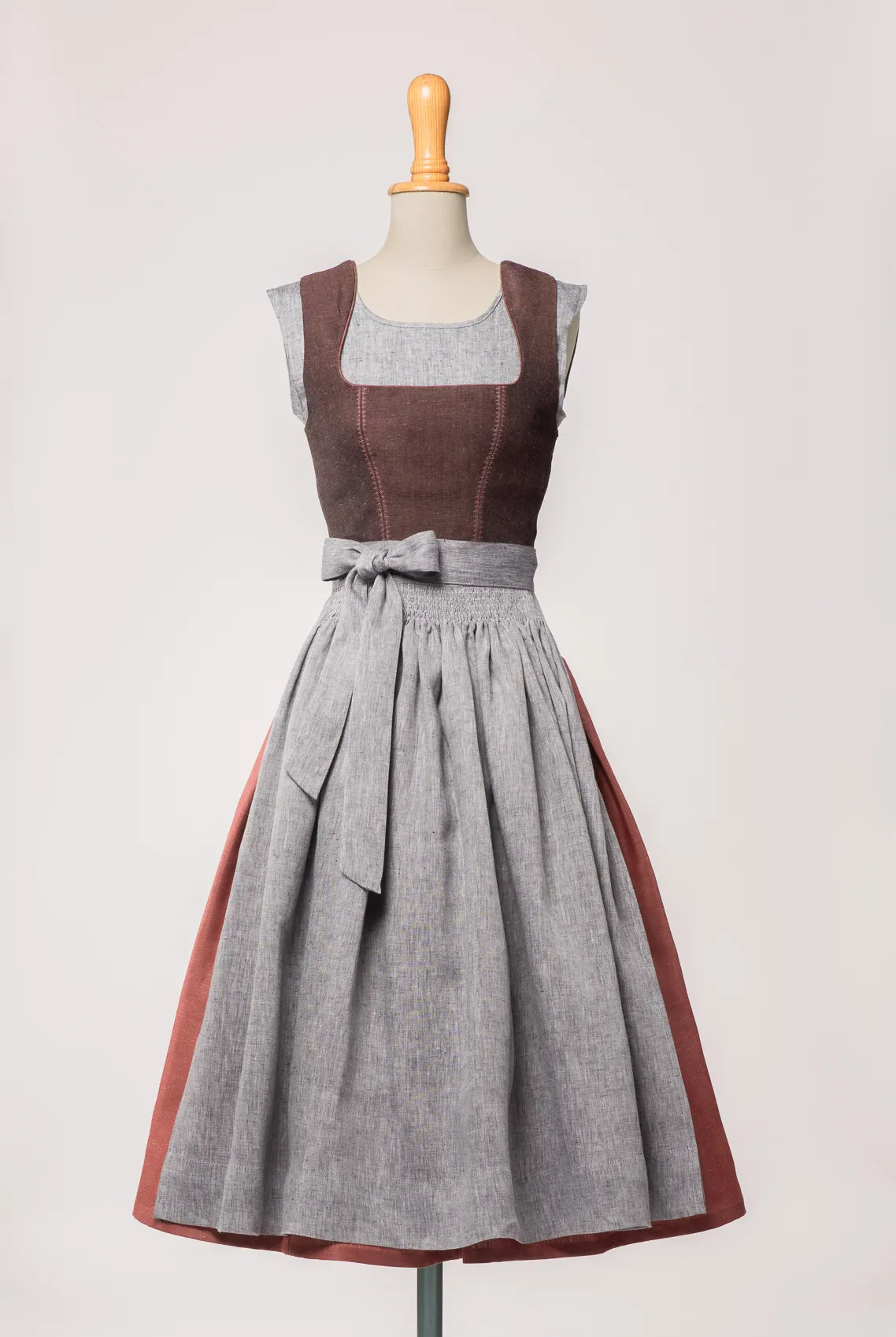 Mieder Ava aus Leinen-Schurwolle-Mischung in Beerenton, kombiniert mit Rock Marlene in pinker Beere und blaugrauer Leinenschürze – Frontansicht auf Büste, handgefertigt in München von Zirbenfux
