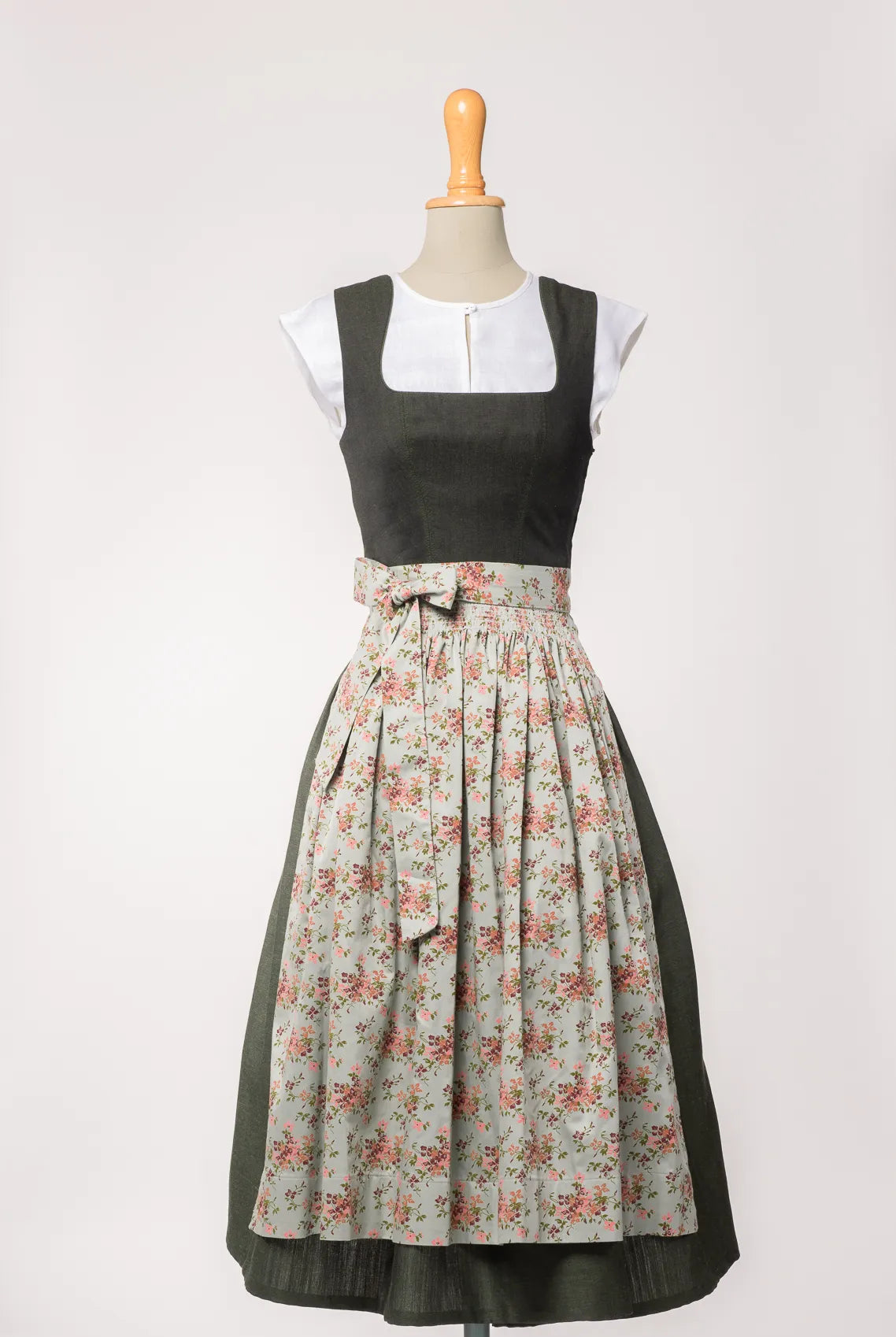 Mieder Ava aus dunkelgrünem Leinen, kombiniert mit Schürze mit Blumenmuster – Frontansicht auf Büste, nachhaltig gefertigt von Zirbenfux