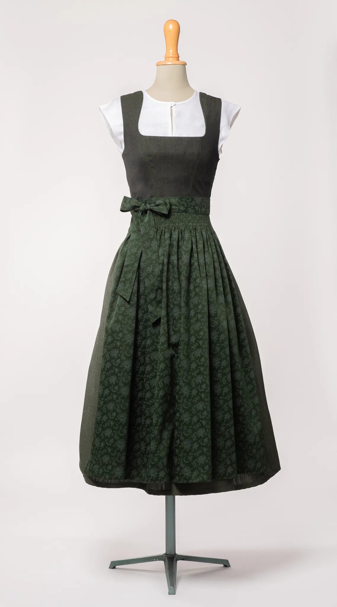Mieder Ava und Trachtenrock Marlene aus dunkelgrünem Leinen, kombiniert mit farblich passender Schürze – Frontansicht auf Büste, handgefertigt von Zirbenfux