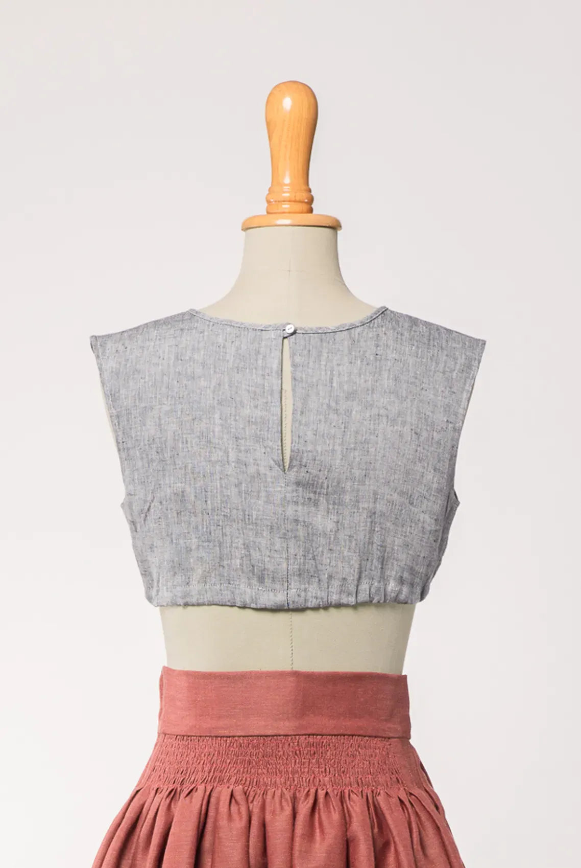 Nahaufnahme der Dirndlbluse Charlie aus blaugrauem Bio-Leinen, kombiniert mit Rock Marlene – Rückansicht auf Büste, zeitlos interpretiert von Zirbenfux