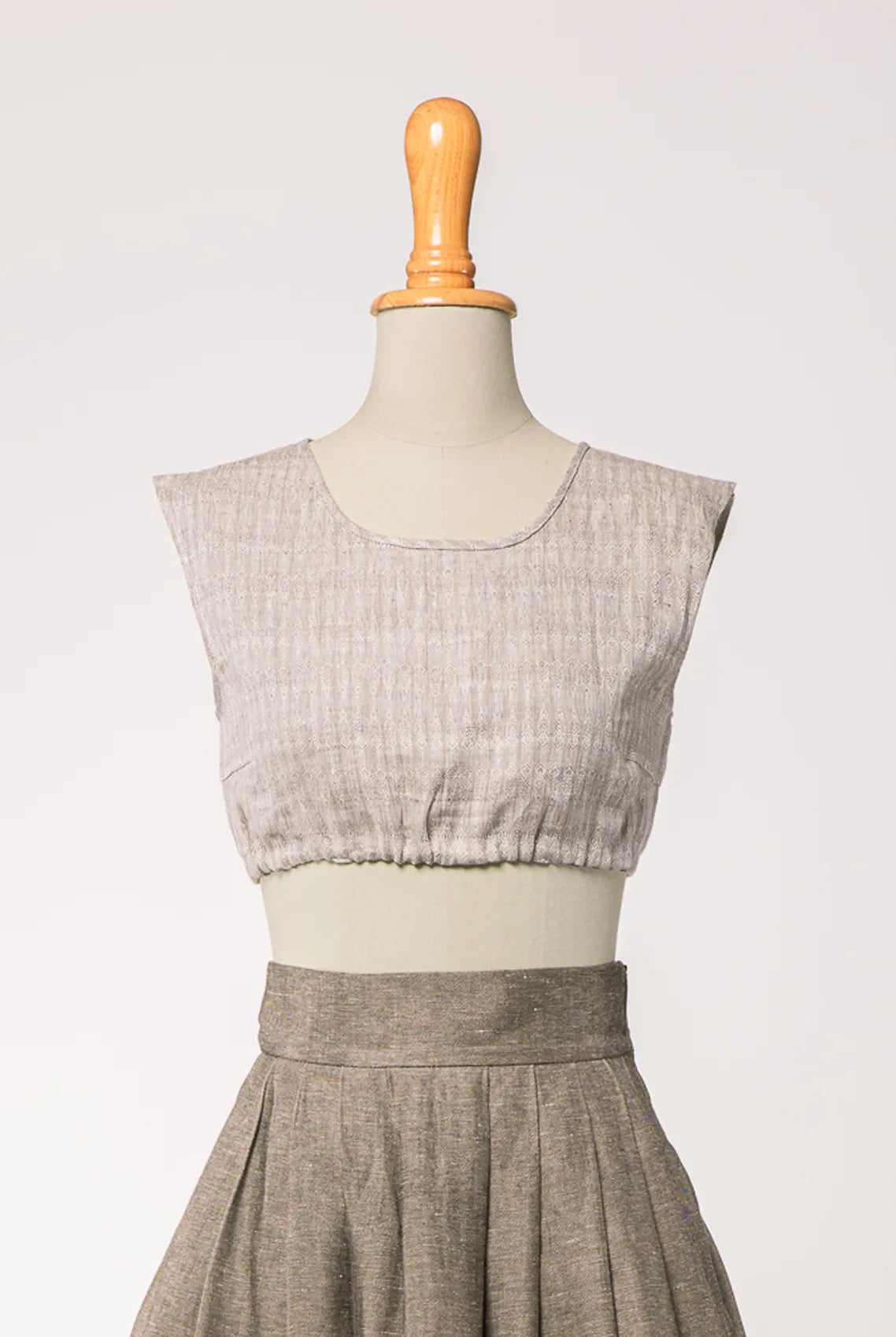 Nahaufnahme von Dirndlbluse Charlie aus naturfarbenem Bio-Leinen mit eingewebtem Muster, kombiniert mit Rock Marlene in goldbraun – Frontansicht auf Büste, handgefertigt von Zirbenfux