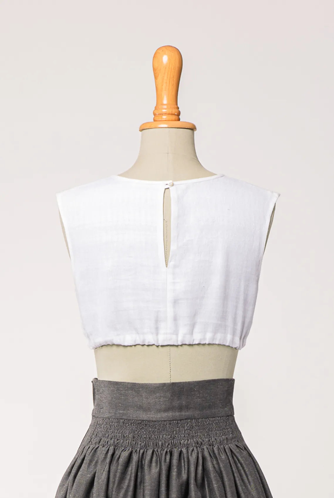 Dirndlbluse Charlie aus weißem Bio-Leinen, kombiniert mit Rock Marlene in Anthrazit – Rückansicht auf Büste, zeitlos interpretiert von Zirbenfux