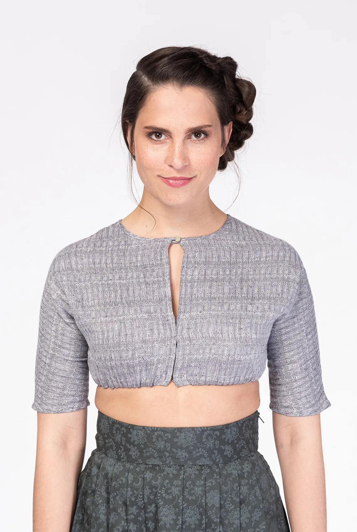 Dirndlbluse Romy aus blaugrauem Bio-Leinen mit eingewebtem Muster – Frontansicht am Model, handgefertigt in München von Zirbenfux