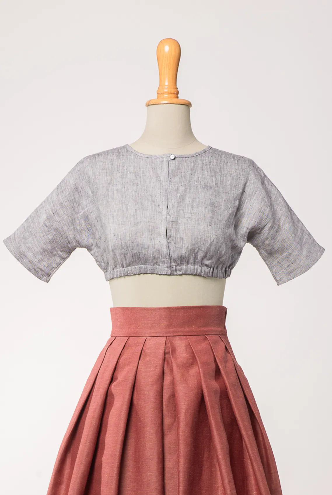 Dirndlbluse Romy aus blaugrauem Bio-Leinen, kombiniert mit Trachtenrock Charlie in pinker Beere – Frontansicht auf Büste, handgefertigt in München von Zirbenfux