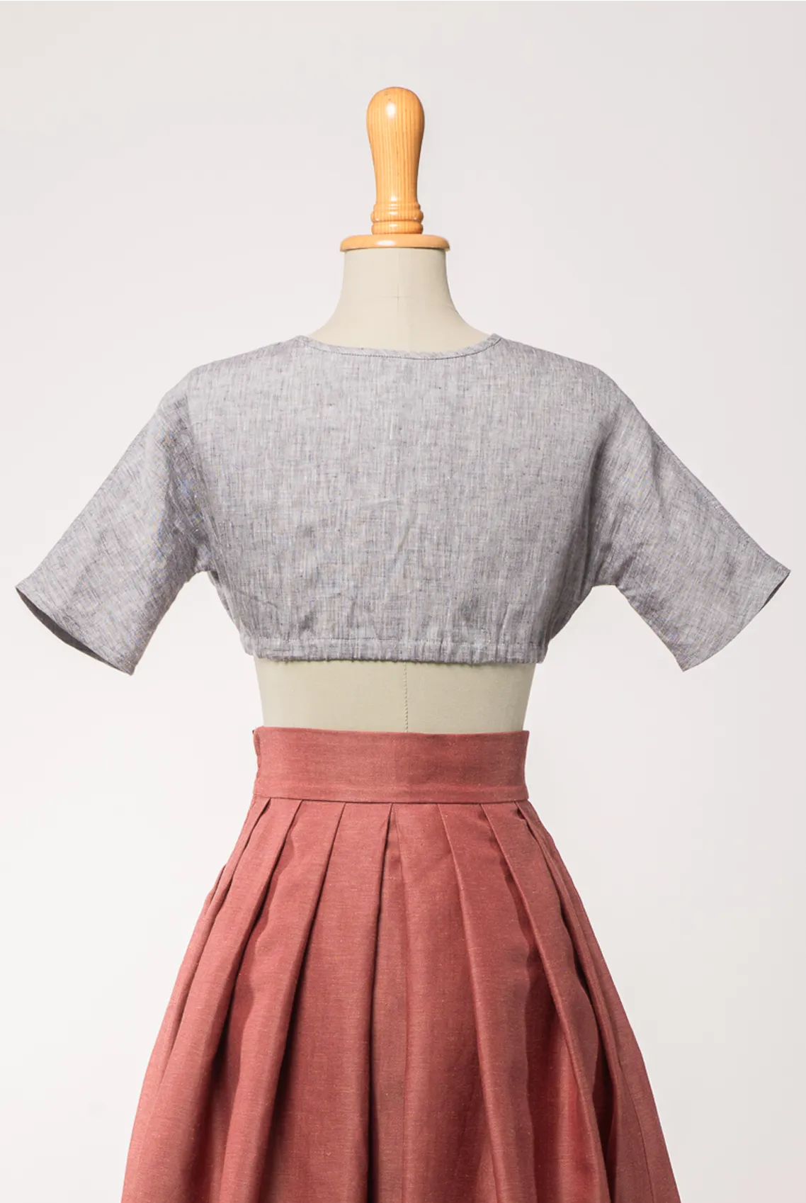 Dirndlbluse Romy aus blaugrauem Bio-Leinen, kombiniert mit Trachtenrock Charlie in pinker Beere – Rückansicht auf Büste, zeitlos interpretiert von Zirbenfux