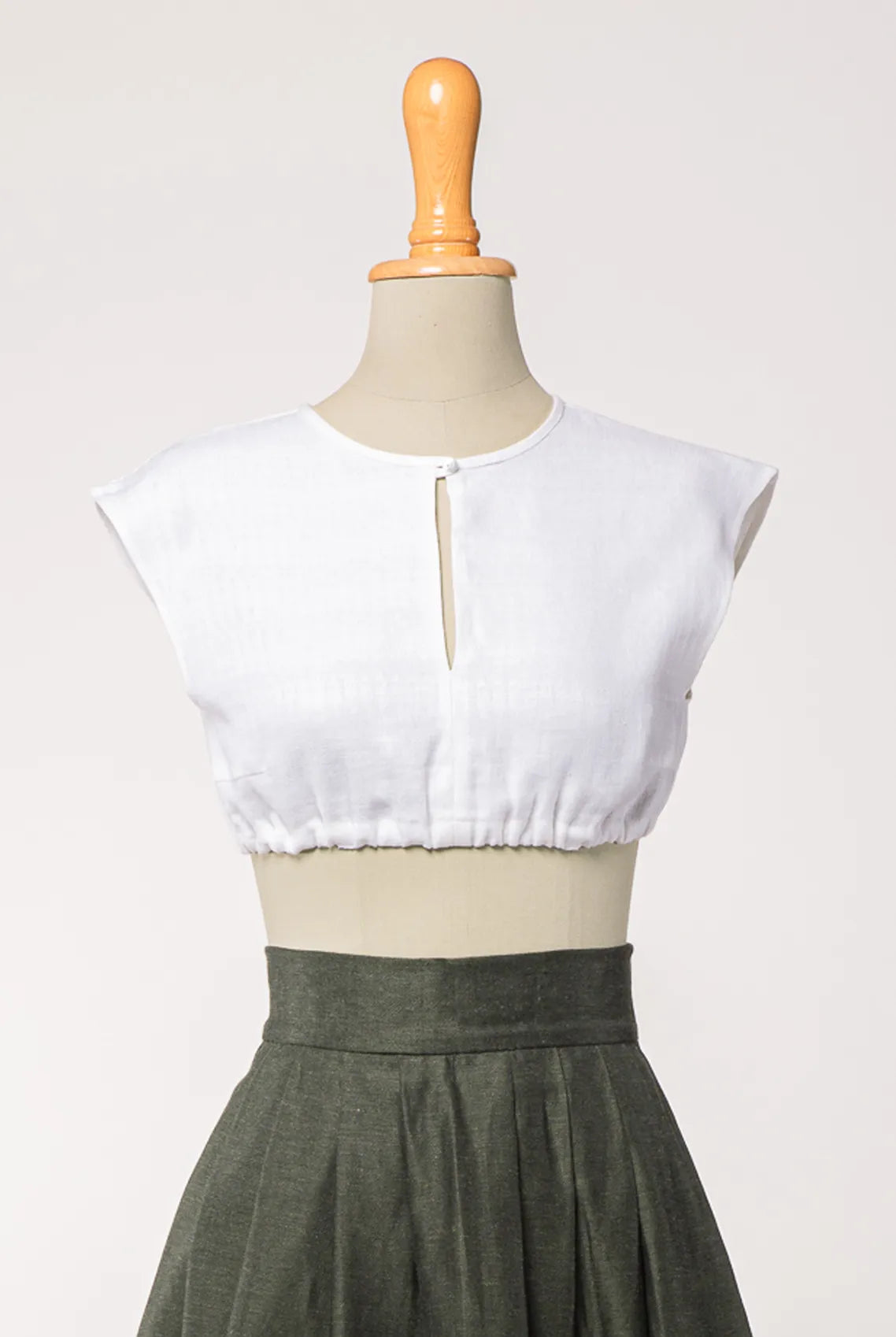 Dirndlbluse Tilda aus weißem Bio-Leinen, kombiniert mit Rock Marlene in dunkelgrün – Frontansicht auf Büste, nachhaltig gefertigt von Zirbenfux