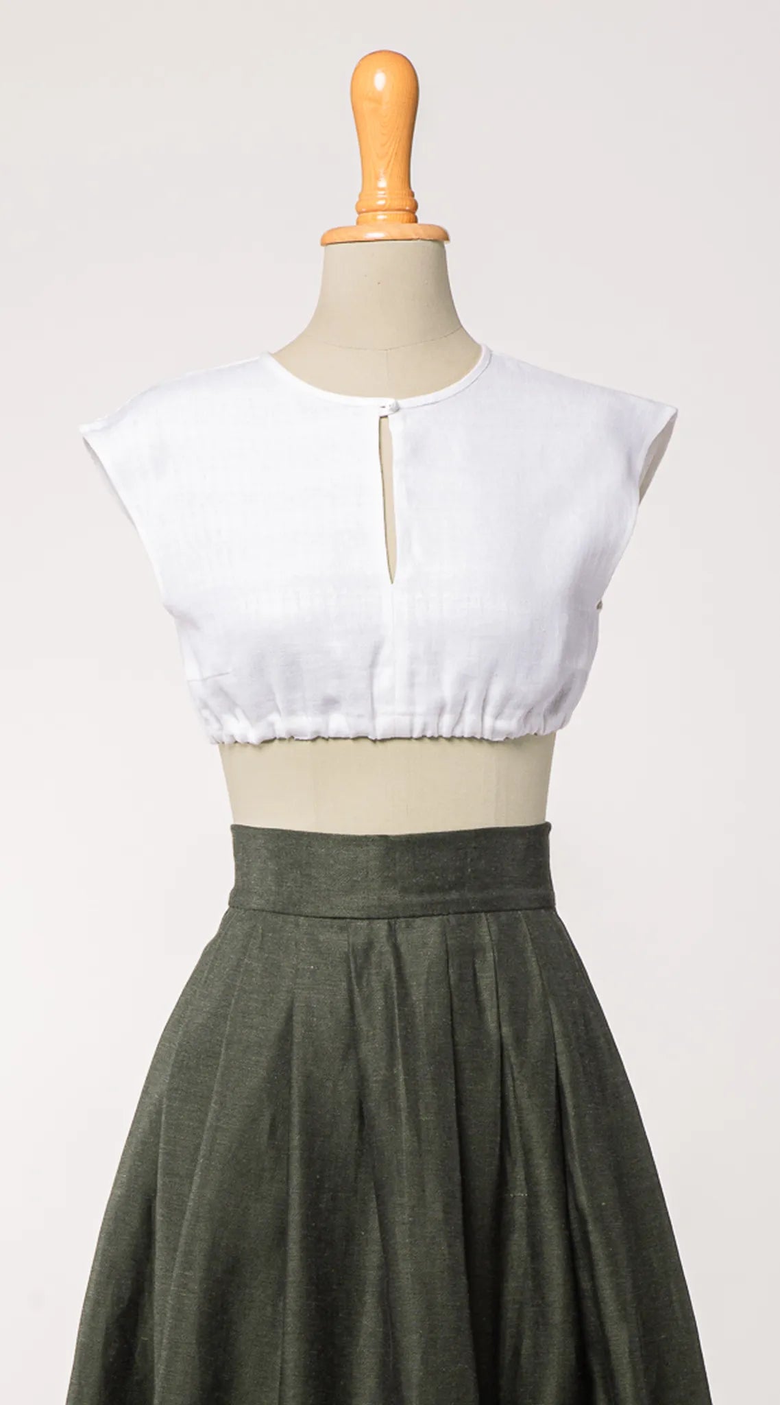 Dirndlbluse Tilda aus weißem Bio-Leinen, kombiniert mit Rock Marlene in dunkelgrün – Frontansicht auf Büste, nachhaltig gefertigt von Zirbenfux