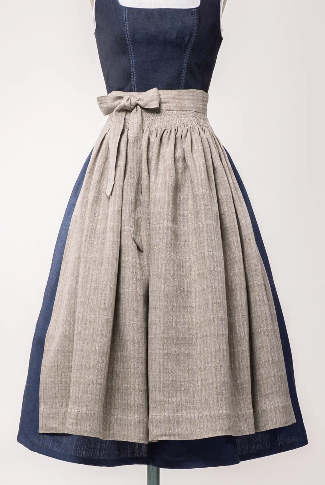 Nahaufnahme Dirndlschürze aus naturfarbenem Bio-Leinen mit eingewebtem Muster – Frontansicht auf Büste, nachhaltig gefertigt von Zirbenfux