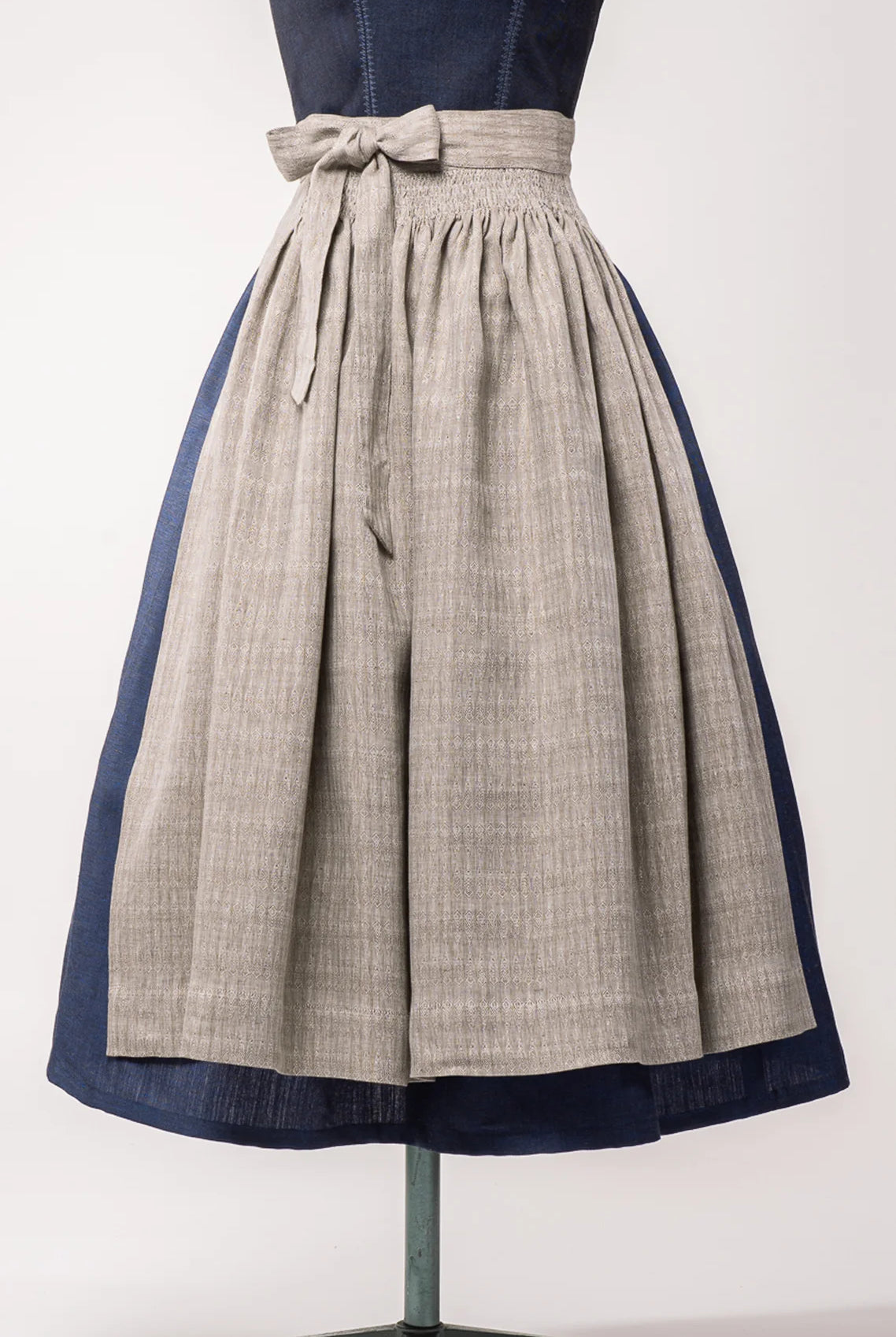 Nahaufnahme Dirndlschürze aus naturfarbenem Bio-Leinen mit eingewebtem Muster – Frontansicht auf Büste, nachhaltig gefertigt von Zirbenfux