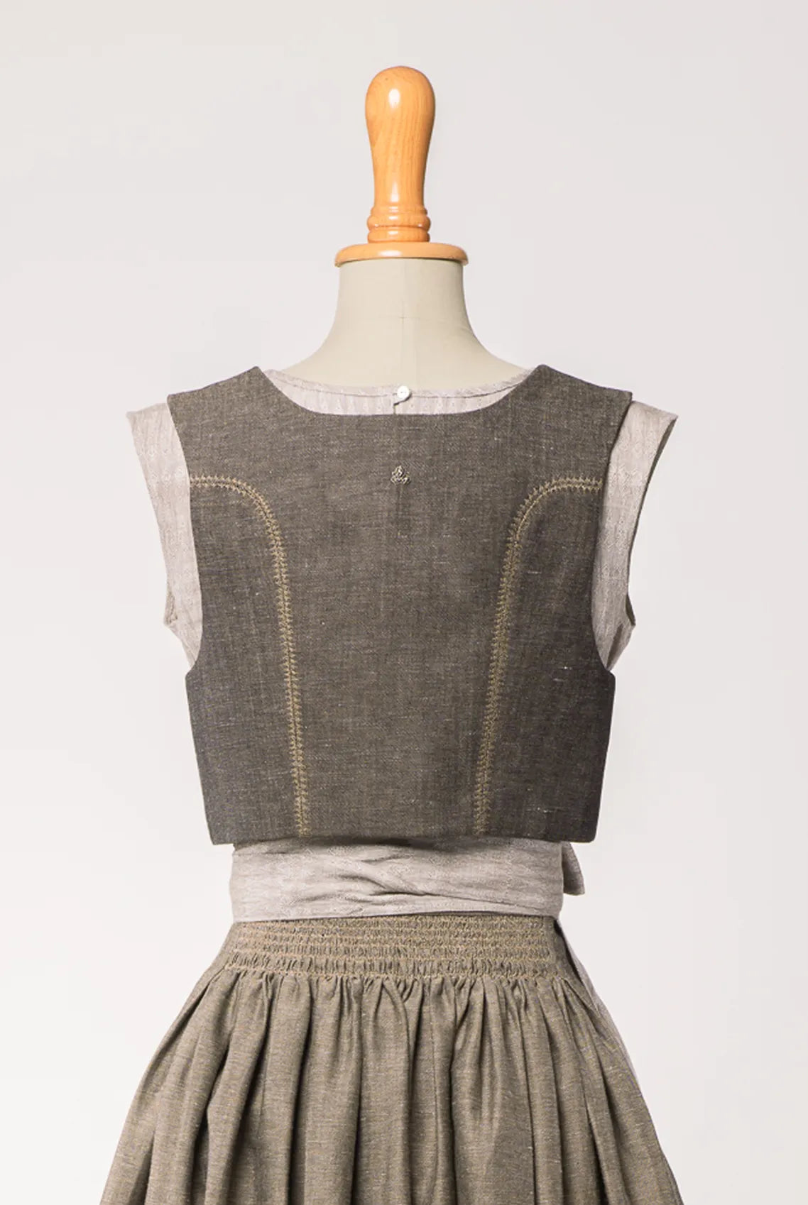 Fuxerl Charlie in gold-naturfarbener Leinen-Schurwolle mit tonalem Zierstich – Rückansicht auf Büste, zeitlos interpretiert von Zirbenfux