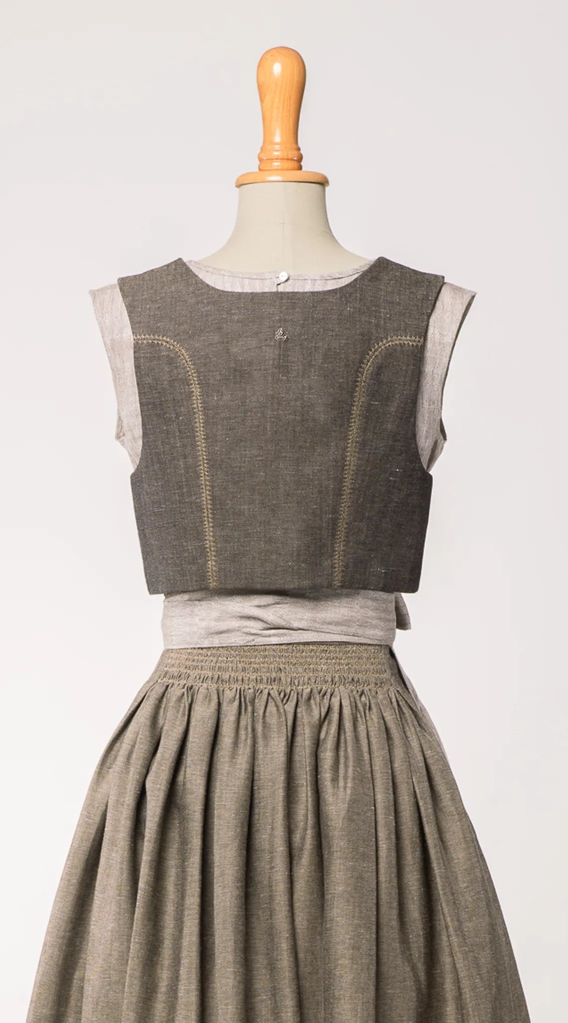 Fuxerl Charlie in gold-naturfarbener Leinen-Schurwolle mit tonalem Zierstich – Rückansicht auf Büste, zeitlos interpretiert von Zirbenfux