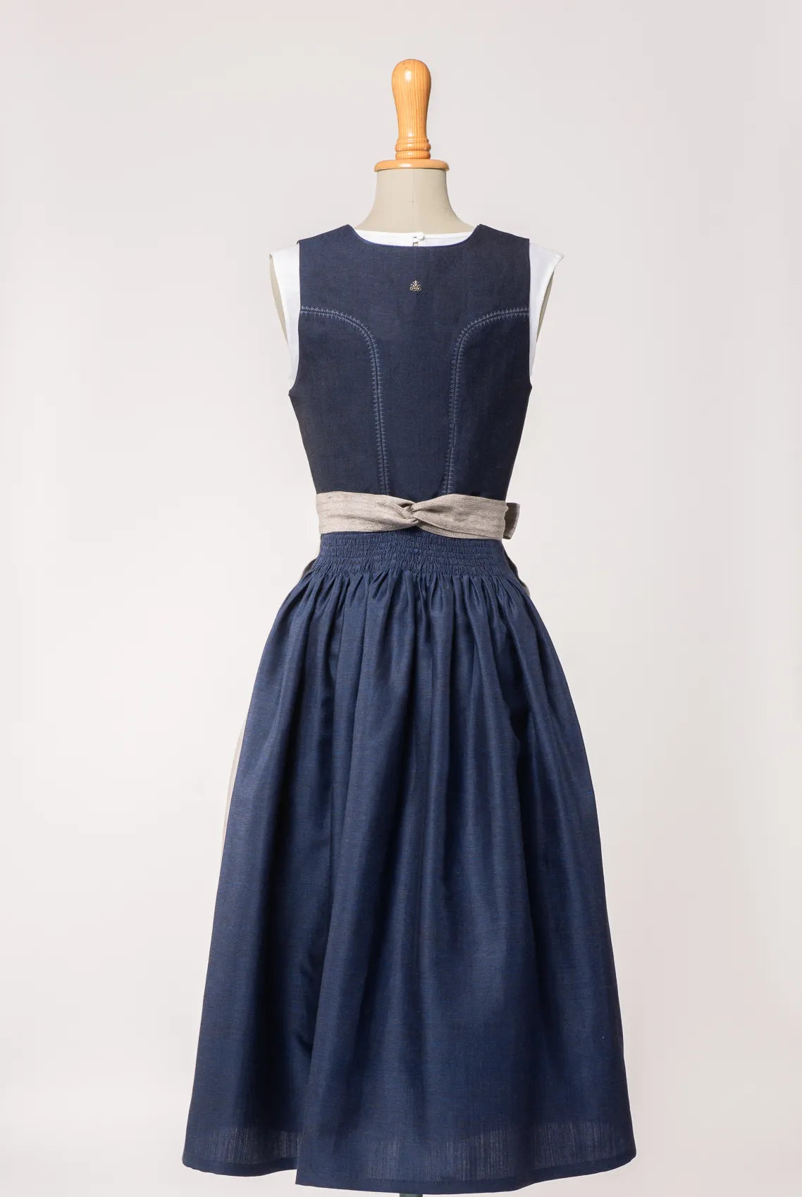 Mieder Ava aus dunkelblauer Leinen-Schurwolle-Mischung, kombiniert mit Rock Marlene und naturfarbener Leinenschürze – Rückansicht auf Büste, handgefertigt in München von Zirbenfux