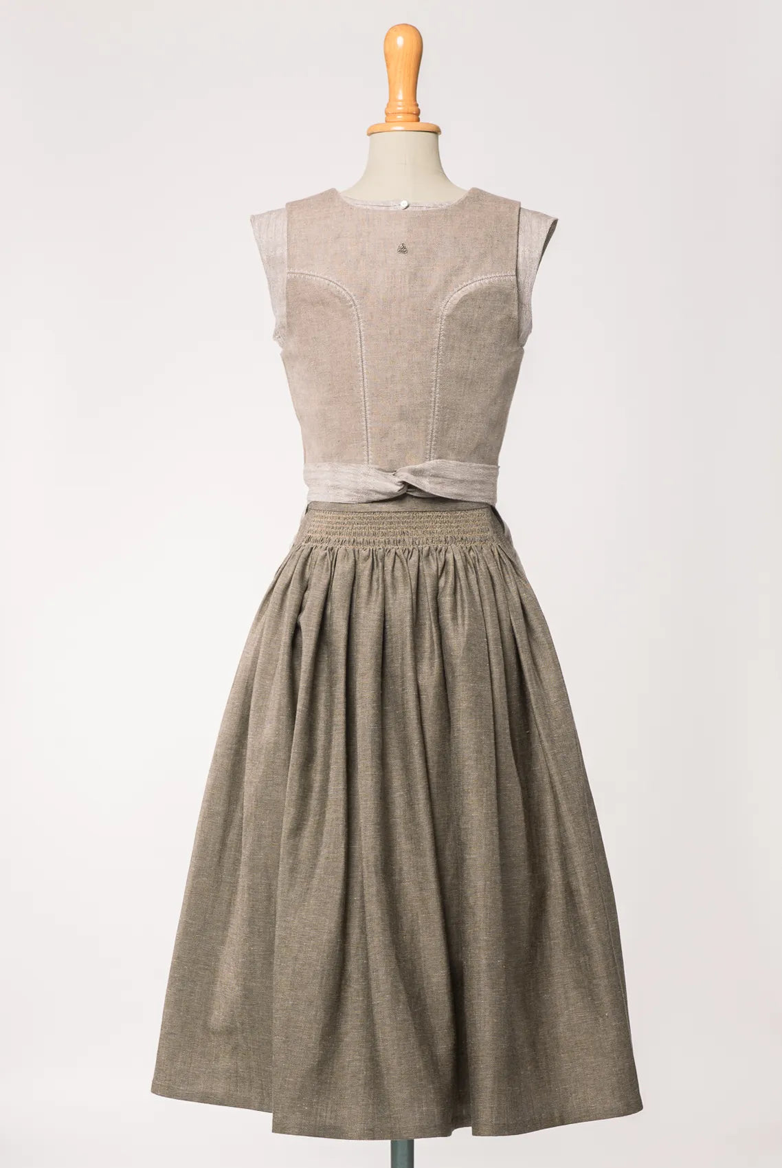 Mieder Ava aus naturfarbenem Bio-Leinen, kombiniert mit Rock Marlene in goldbraun und naturfarbener Leinenschürze – Rückansicht auf Büste, handgefertigt in München von Zirbenfux