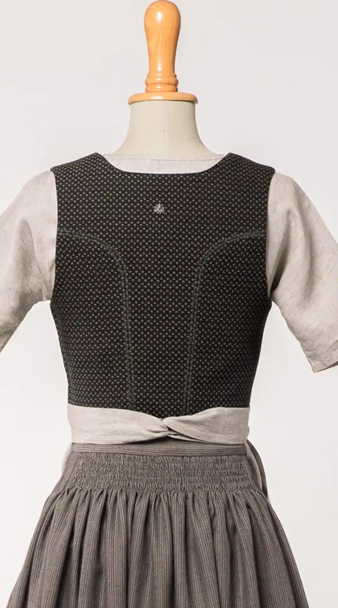 Mieder Ava aus Schurwolle in Schwarz, Rückansicht auf Büste mit feinem Webmuster, präsentiert von Zirbenfux.