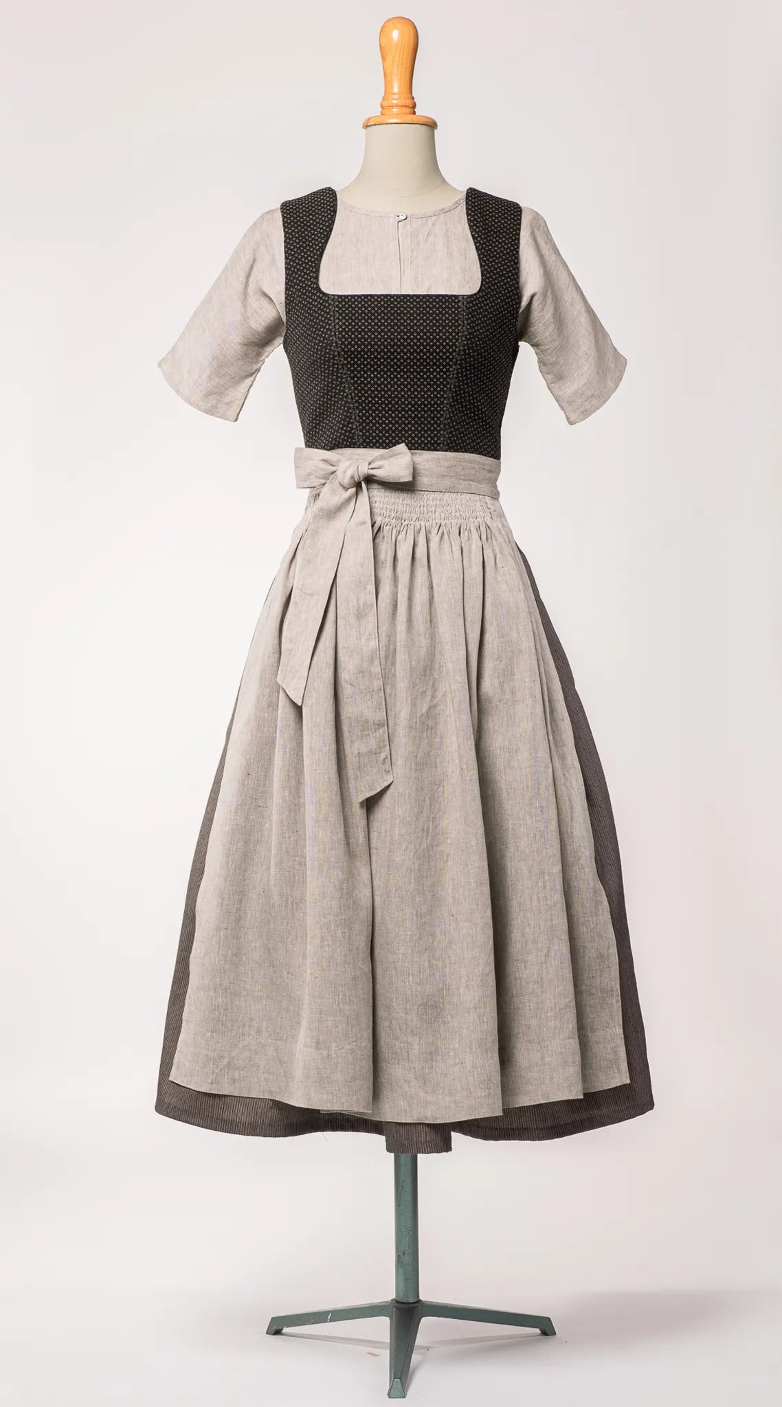 Mieder Ava aus schwarzer Schurwolle mit Webmuster, kombiniert mit Rock Marlene und naturfarbener Leinenschürze – Frontansicht auf Büste, handgefertigt in München von Zirbenfux