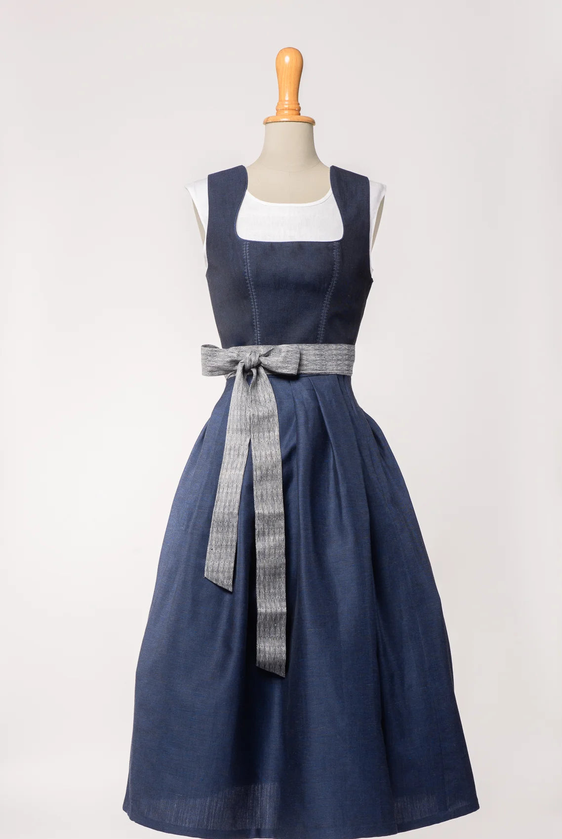Schürzenband aus blaugrauem Bio-Leinen mit eingewebtem Muster, kombiniert mit Mieder und Rock in dunkelblau – Ansicht auf Büste, handgefertigt in München von Zirbenfux