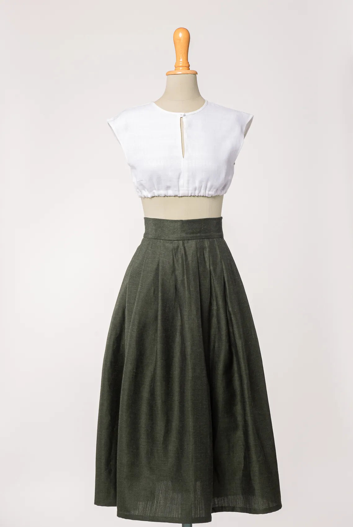 Trachtenrock Marlene aus dunkelgrüner Leinen-Schurwolle-Mischung, kombiniert mit Dirndlbluse Tilda aus weißem Bio-Leinen – Frontansicht auf Büste, handgefertigt von Zirbenfux