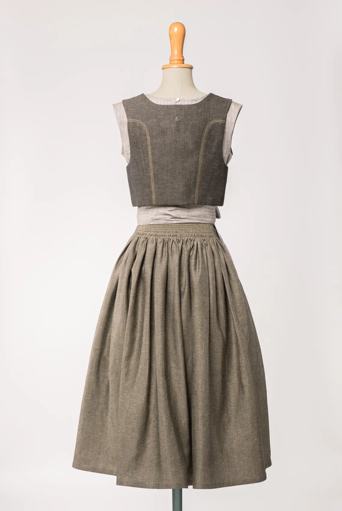 Trachtenrock Marlene aus naturfarbenem Leinen, kombiniert mit Fuxerl Charlie und naturfarbener Leinenschürze – Rückansicht auf Büste, nachhaltig gefertigt von Zirbenfux
