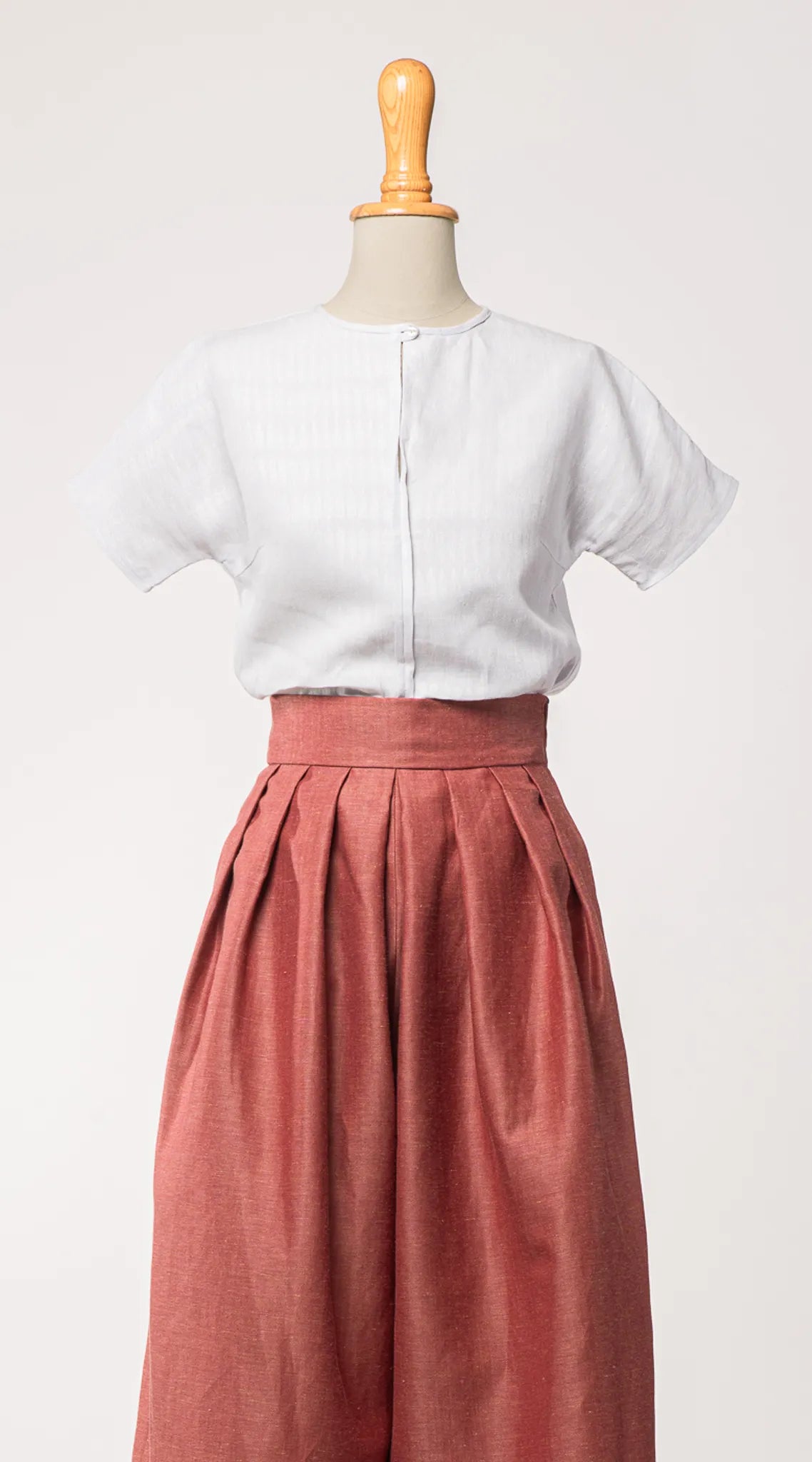 Bluse Romy aus Bio-Leinen in hellem wasserblau, kombiniert mit Hosenrock Audrey in pinker Beere – Frontansicht auf Büste, nachhaltig gefertigt von Zirbenfux