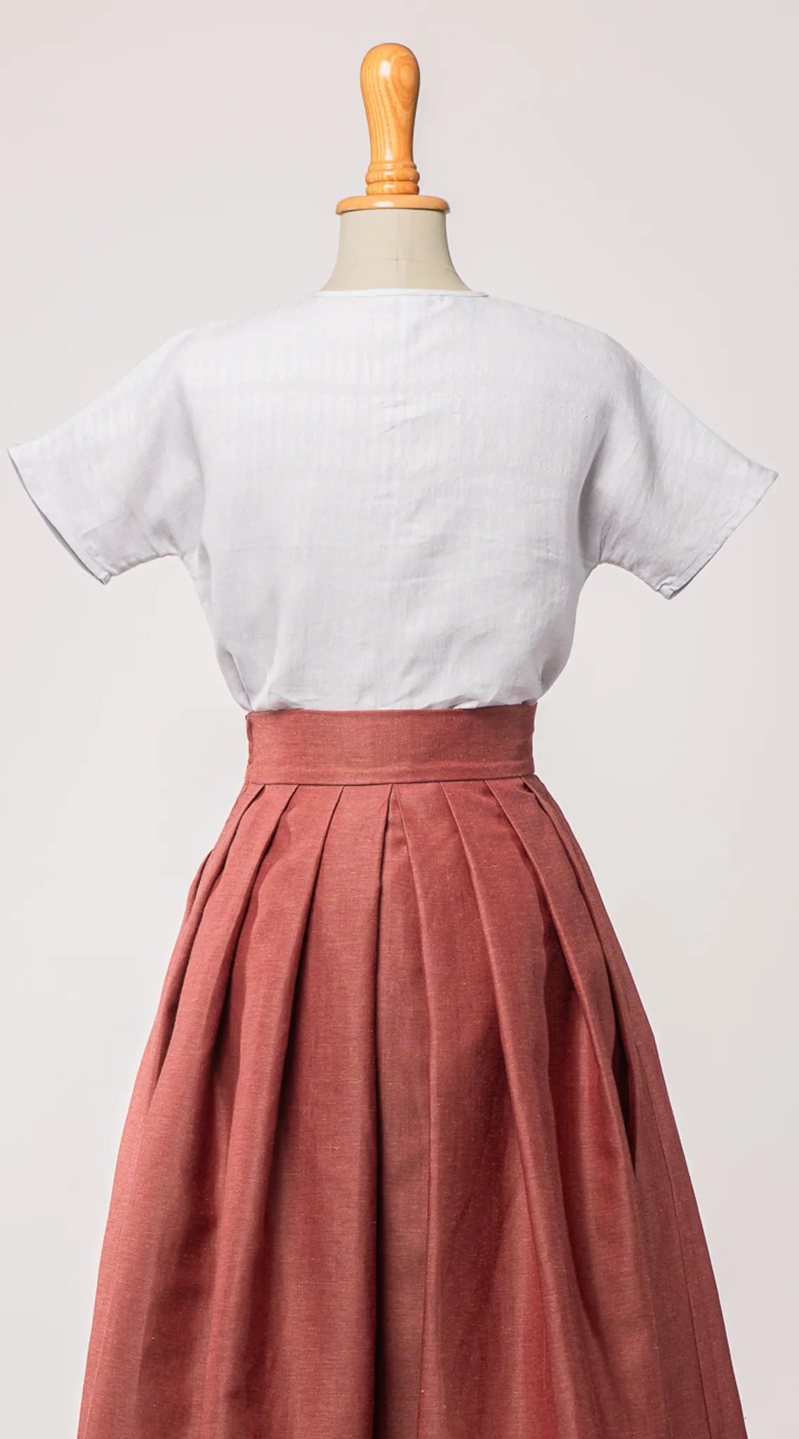 Bluse Romy aus Bio-Leinen in hellem wasserblau, kombiniert mit Trachtenrock Charlie in pinker Beere – Rückansicht auf Büste, nachhaltig gefertigt von Zirbenfux