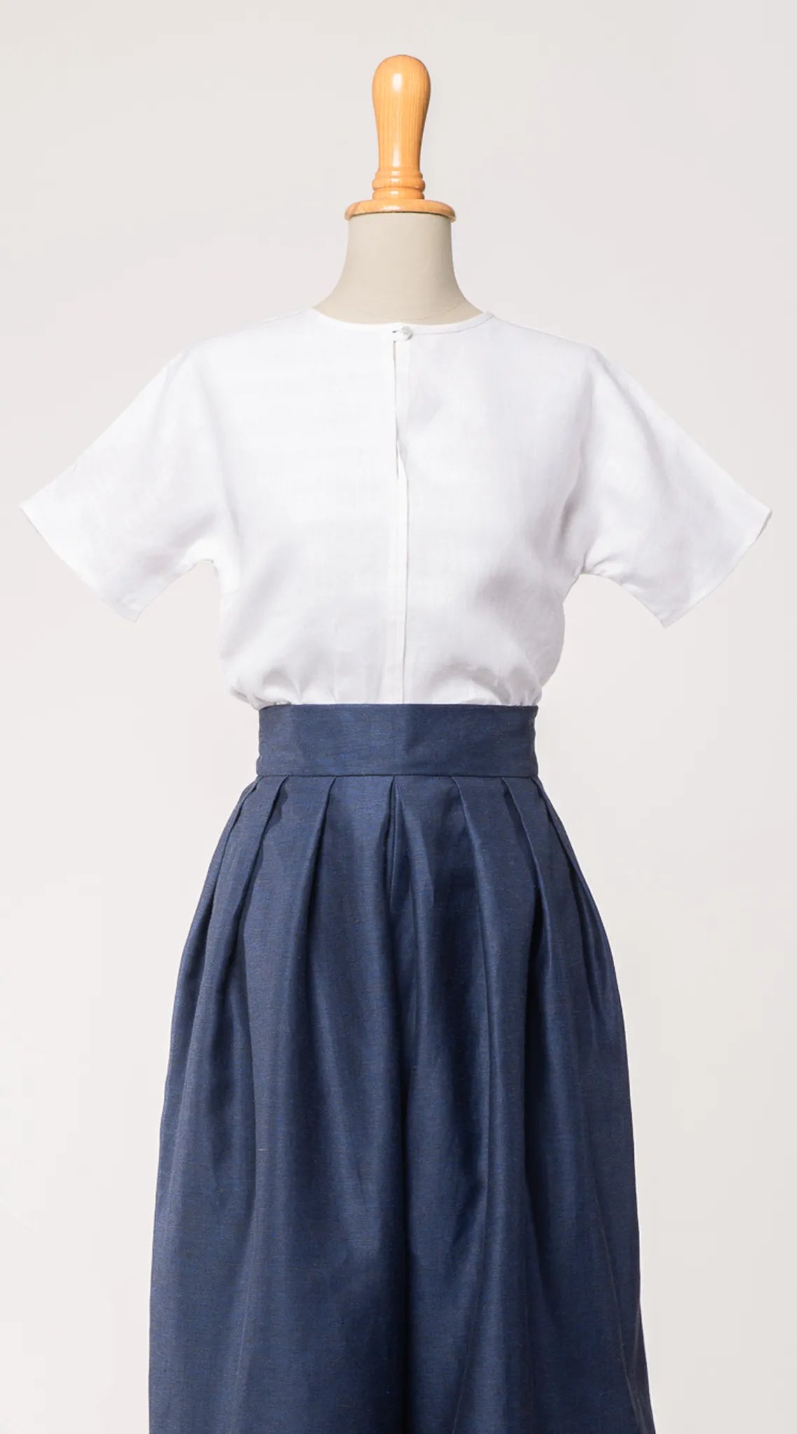 Bluse Romy aus weißem Bio-Leinen, kombiniert mit Hosenrock Audrey in Tintenblau – Frontansicht auf Büste, handgefertigt in München von Zirbenfux