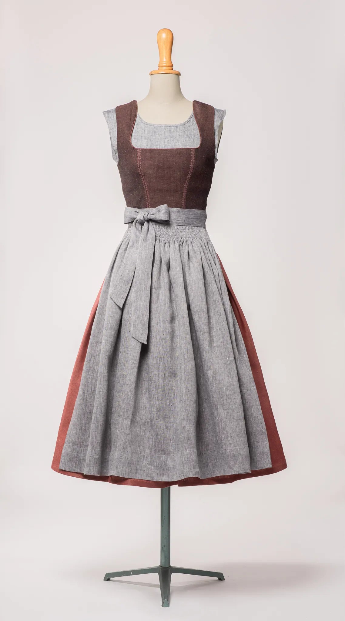 Mieder Ava aus Leinen-Schurwolle-Mischung in Beerenton, kombiniert mit Rock Marlene in pinker Beere und blaugrauer Leinenschürze – Frontansicht auf Büste, handgefertigt in München von Zirbenfux