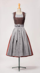 Mieder Ava aus Leinen-Schurwolle-Mischung in Beerenton, kombiniert mit Rock Marlene in pinker Beere und blaugrauer Leinenschürze – Frontansicht auf Büste, handgefertigt in München von Zirbenfux