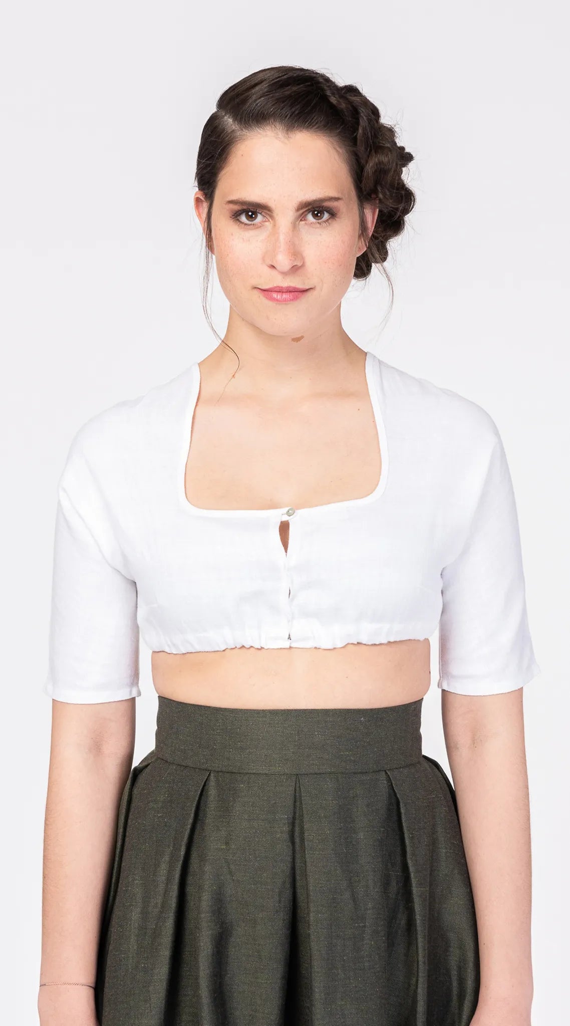 Nahaufnahme der Dirndlbluse Ava aus weißem Bio-Leinen – Frontansicht am Model, handgefertigt in München von Zirbenfux