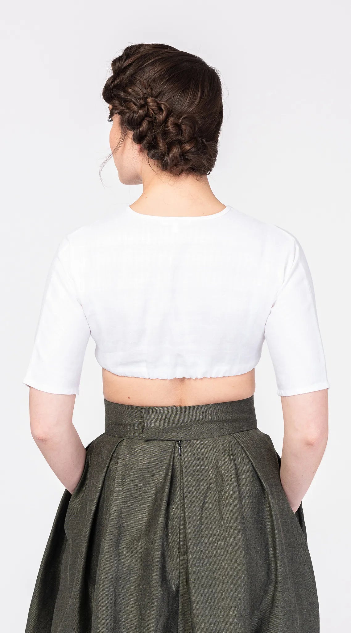 Nahaufnahme der Dirndlbluse Ava aus weißem Bio-Leinen – Rückansicht am Model, nachhaltig gefertigt von Zirbenfux