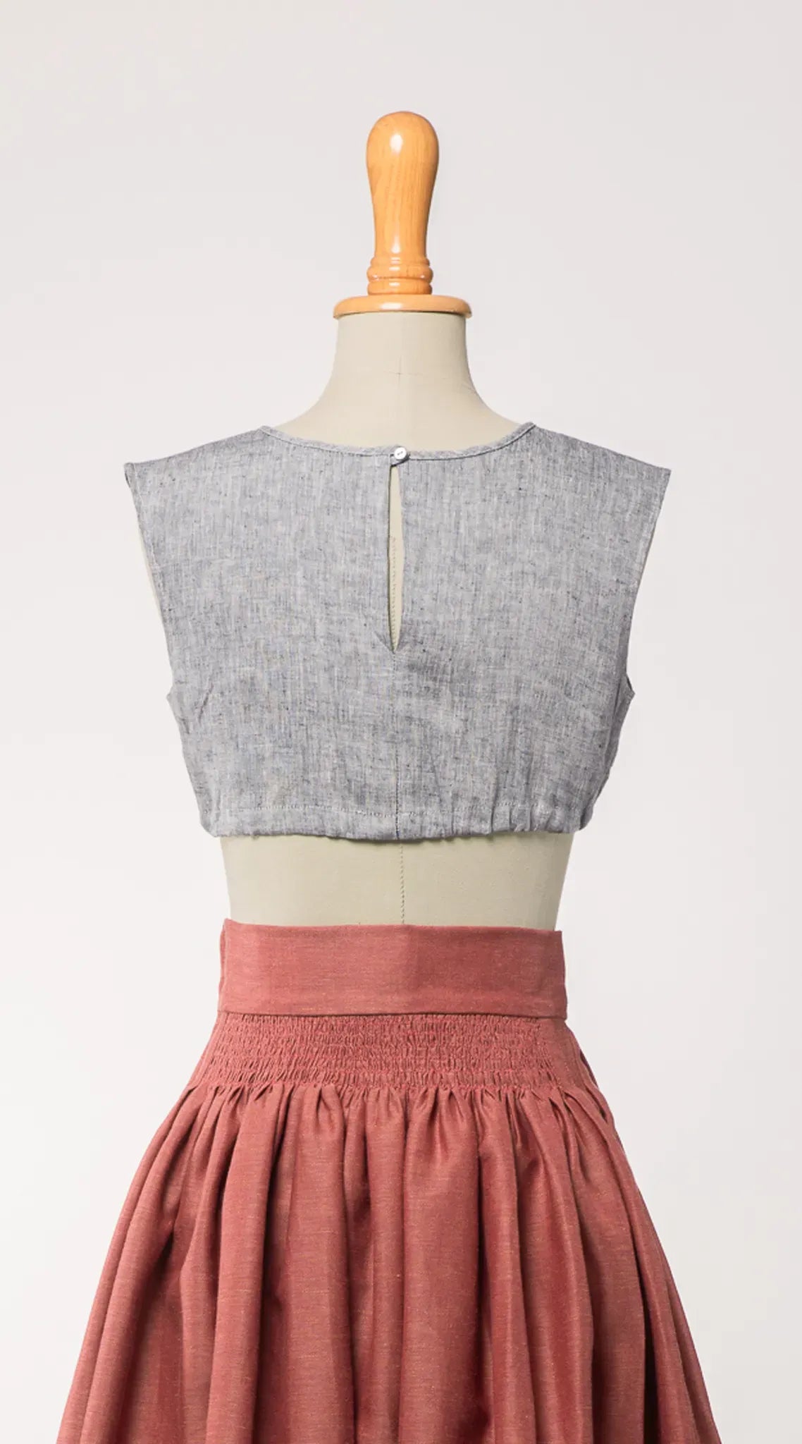 Nahaufnahme der Dirndlbluse Charlie aus blaugrauem Bio-Leinen, kombiniert mit Rock Marlene – Rückansicht auf Büste, zeitlos interpretiert von Zirbenfux