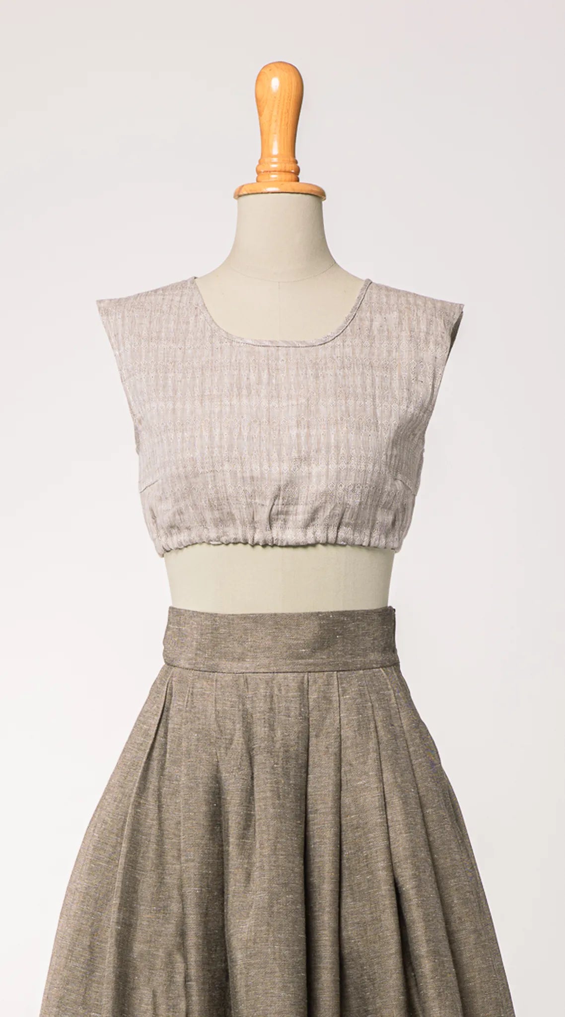 Nahaufnahme von Dirndlbluse Charlie aus naturfarbenem Bio-Leinen mit eingewebtem Muster, kombiniert mit Rock Marlene in goldbraun – Frontansicht auf Büste, handgefertigt von Zirbenfux