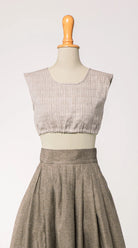 Nahaufnahme von Dirndlbluse Charlie aus naturfarbenem Bio-Leinen mit eingewebtem Muster, kombiniert mit Rock Marlene in goldbraun – Frontansicht auf Büste, handgefertigt von Zirbenfux