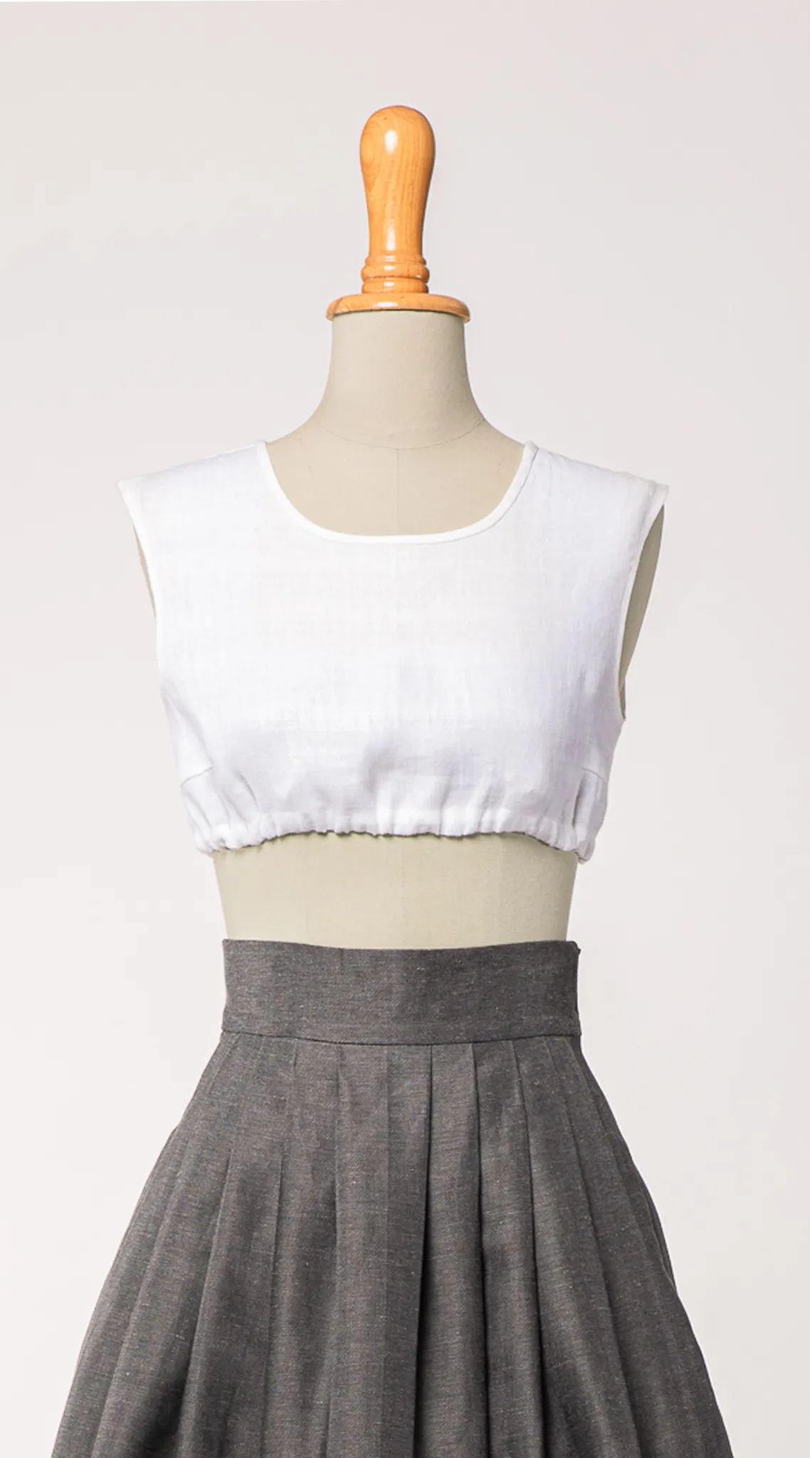 Dirndlbluse Charlie aus weißem Bio-Leinen, kombiniert mit Rock Marlene in Anthrazit – Frontansicht auf Büste, handgefertigt in München von Zirbenfux