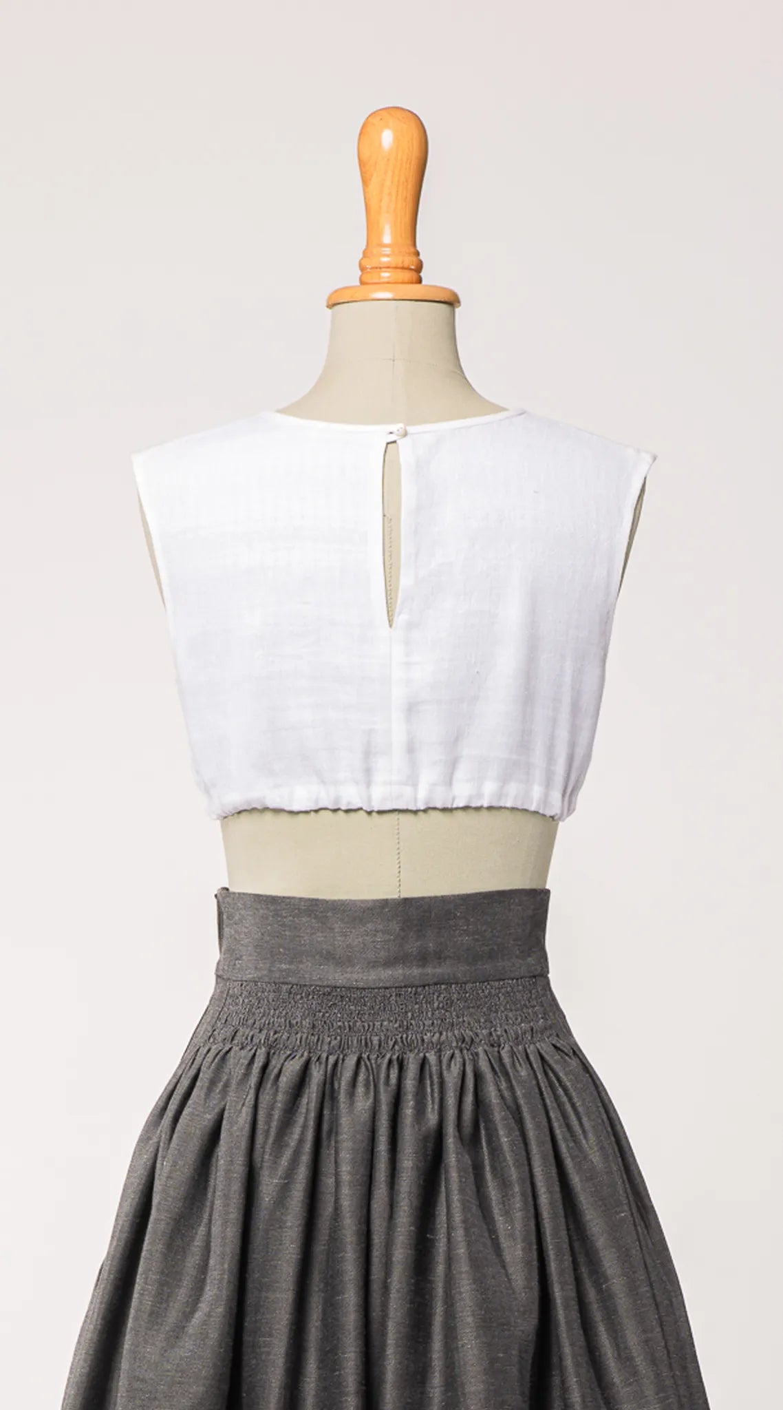 Dirndlbluse Charlie aus weißem Bio-Leinen, kombiniert mit Rock Marlene in Anthrazit – Rückansicht auf Büste, zeitlos interpretiert von Zirbenfux