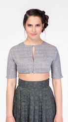 Dirndlbluse Romy aus blaugrauem Bio-Leinen mit eingewebtem Muster – Frontansicht am Model, handgefertigt in München von Zirbenfux