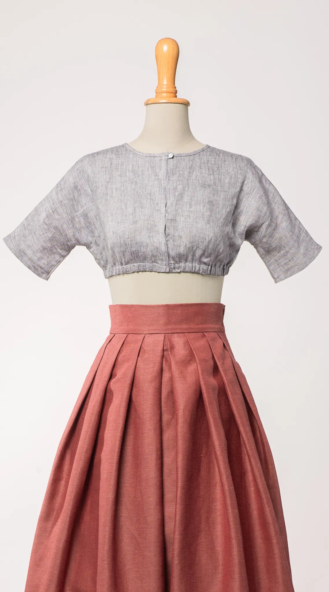 Dirndlbluse Romy aus blaugrauem Bio-Leinen, kombiniert mit Trachtenrock Charlie in pinker Beere – Frontansicht auf Büste, handgefertigt in München von Zirbenfux