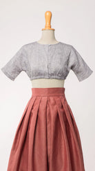 Dirndlbluse Romy aus blaugrauem Bio-Leinen, kombiniert mit Trachtenrock Charlie in pinker Beere – Frontansicht auf Büste, handgefertigt in München von Zirbenfux