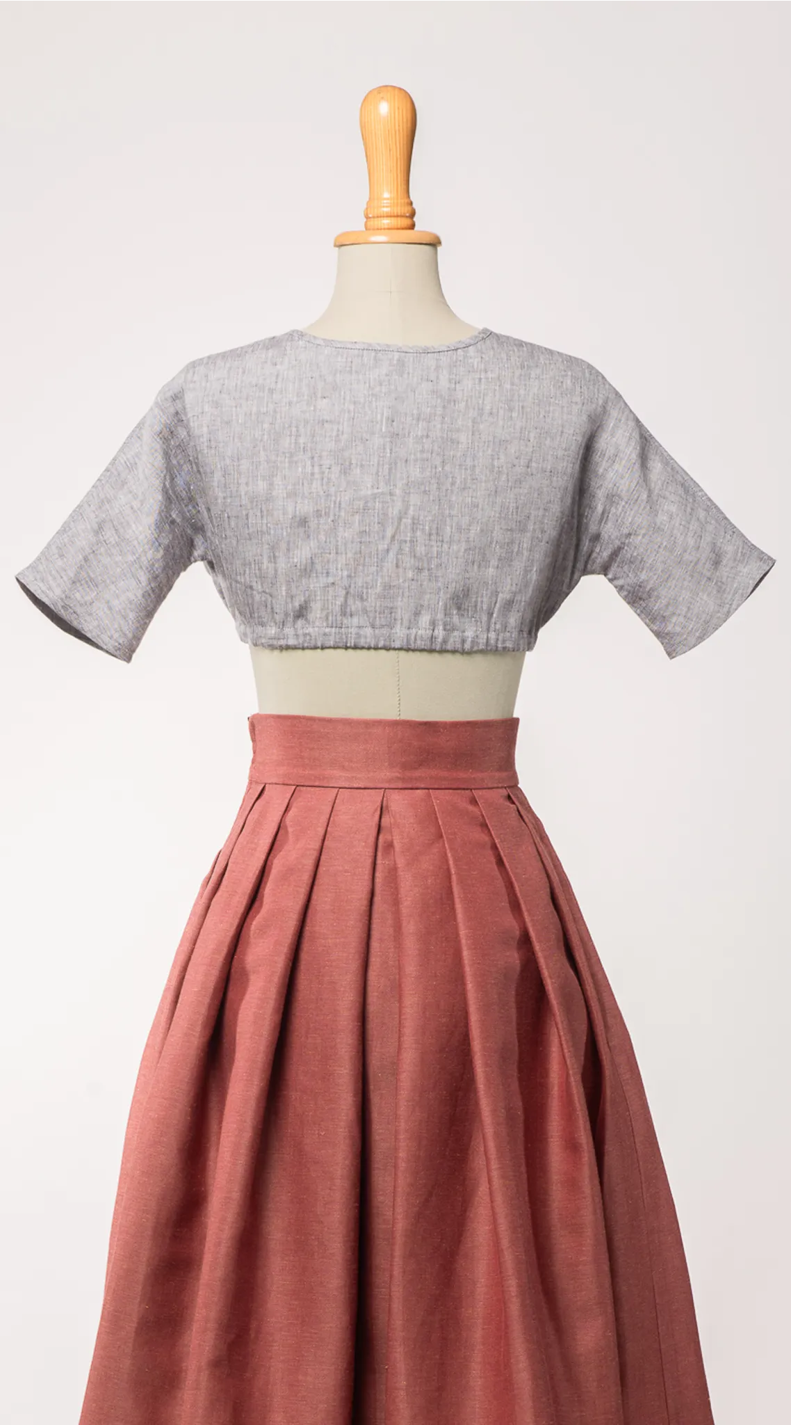 Dirndlbluse Romy aus blaugrauem Bio-Leinen, kombiniert mit Trachtenrock Charlie in pinker Beere – Rückansicht auf Büste, zeitlos interpretiert von Zirbenfux