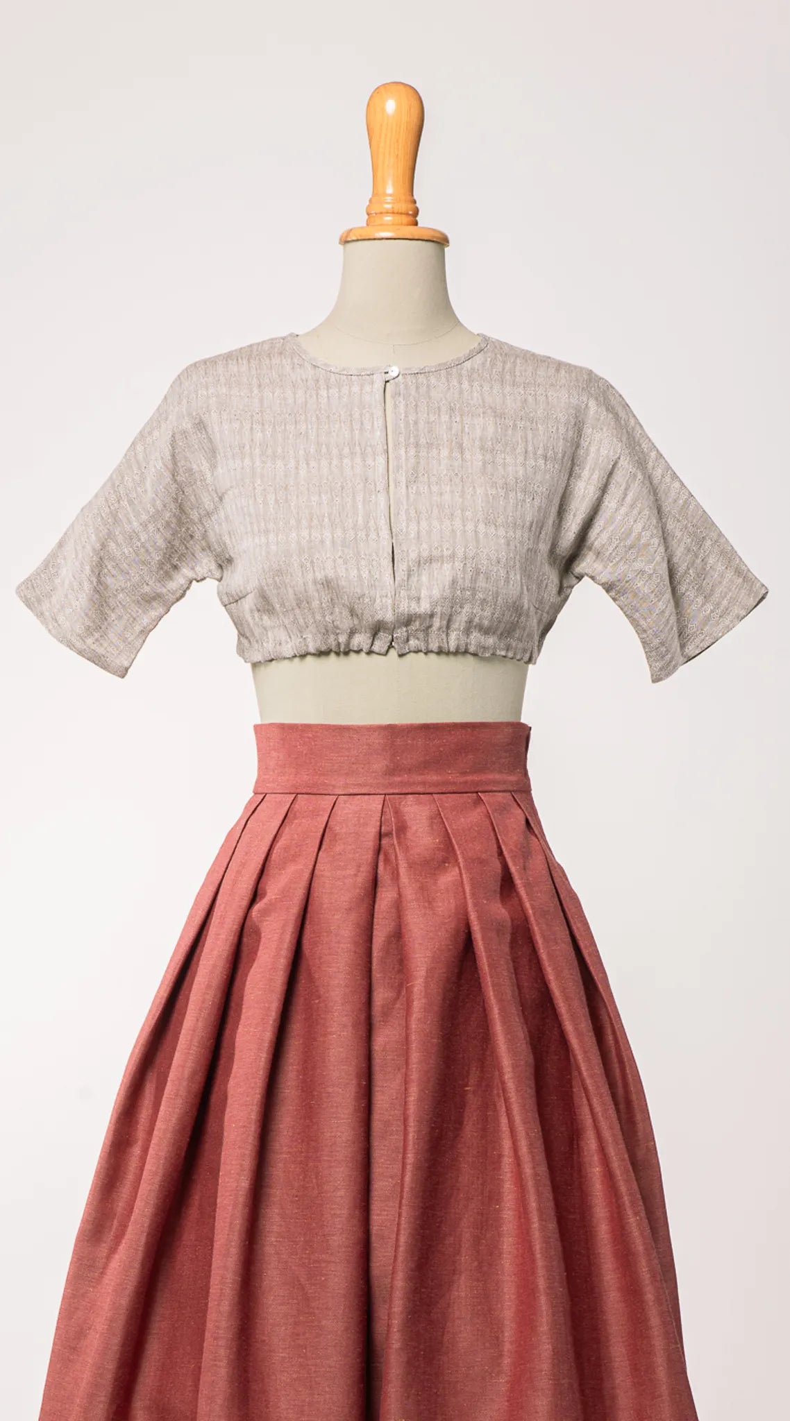 Dirndlbluse Romy aus naturfarbenem Bio-Leinen mit eingewebtem Muster, kombiniert mit Trachtenrock Charlie in pinker Beere – Frontansicht auf Büste, handgefertigt in München von Zirbenfux