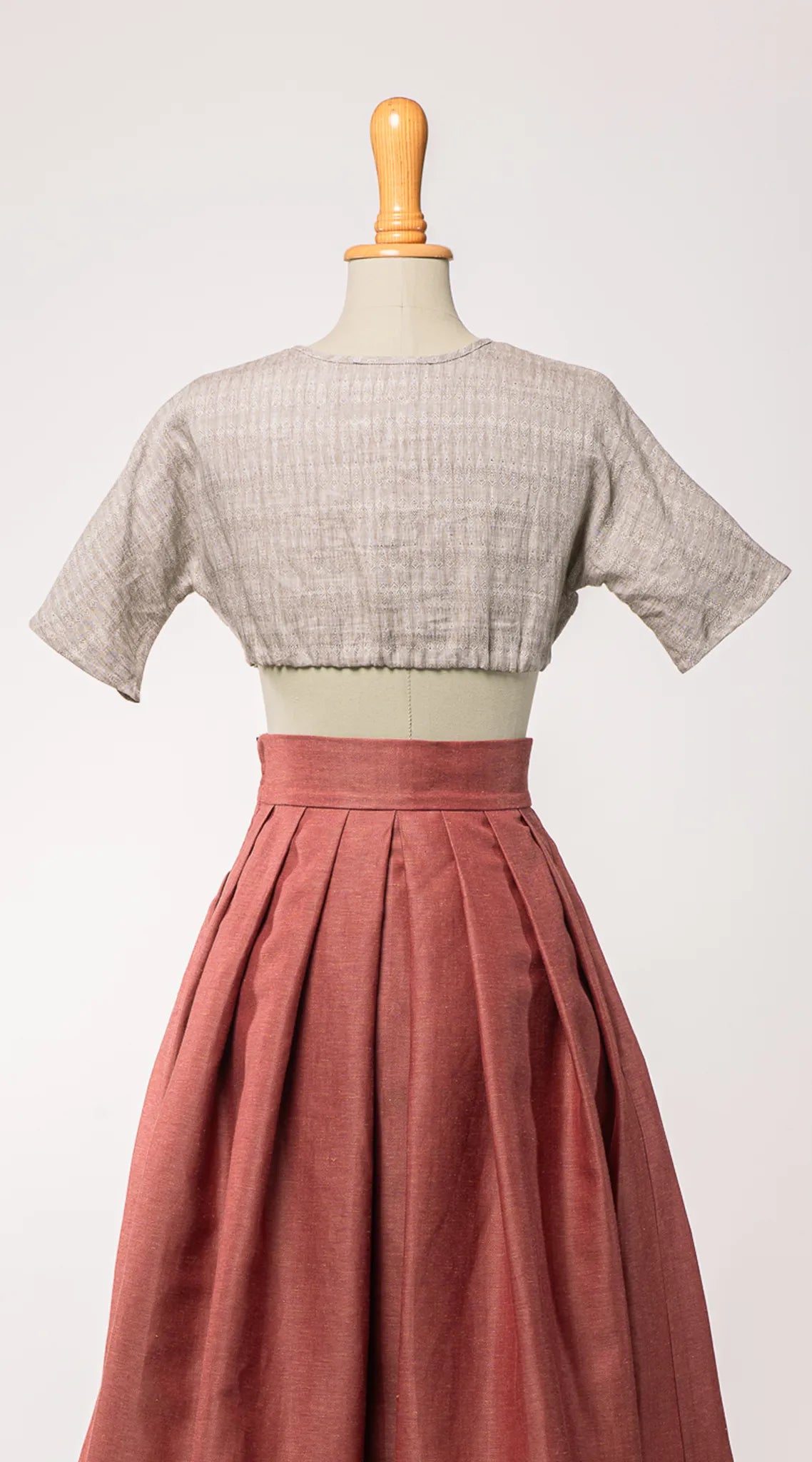 Dirndlbluse Romy aus naturfarbenem Bio-Leinen mit eingewebtem Muster, kombiniert mit Trachtenrock Charlie in pinker Beere – Rückansicht auf Büste, nachhaltig gefertigt von Zirbenfux