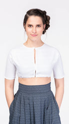 Dirndlbluse Romy hochgeschlossen aus weißem Bio-Leinen – Frontansicht am Model, nachhaltig gefertigt von Zirbenfux