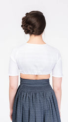 Dirndlbluse Romy hochgeschlossen aus weißem Bio-Leinen – Rückansicht am Model, handgefertigt von Zirbenfux