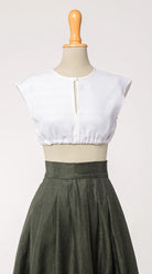 Dirndlbluse Tilda aus weißem Bio-Leinen, kombiniert mit Rock Marlene in dunkelgrün – Frontansicht auf Büste, nachhaltig gefertigt von Zirbenfux