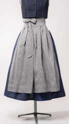 Dirndlschürze aus blaugrauem Bio-Leinen auf Büste – Frontansicht, handgefertigt & nachhaltig von Zirbenfux