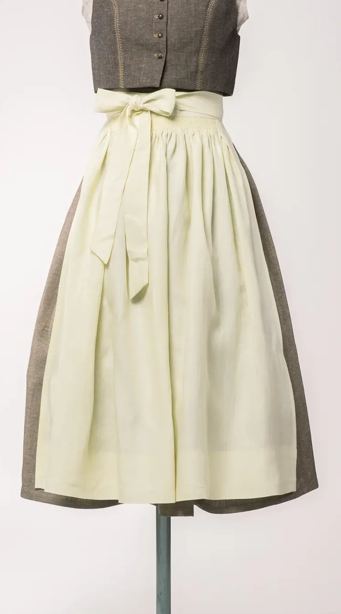 Dirndlschürze aus reinem Leinen in Farbe buttergelb – Frontansicht auf Büste, handgefertigt in München von Zirbenfux