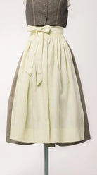 Dirndlschürze aus reinem Leinen in Farbe buttergelb – Frontansicht auf Büste, handgefertigt in München von Zirbenfux